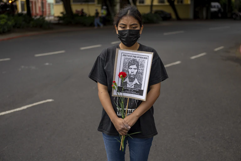 A woman holds a portrait of a man who was allegedly disappeared by the Guatemalan Army