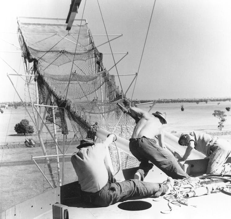 Construction workers building the dish