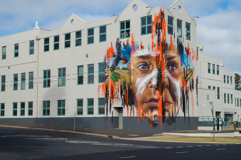 A mural of an Aboriginal young person on the corner of a building.