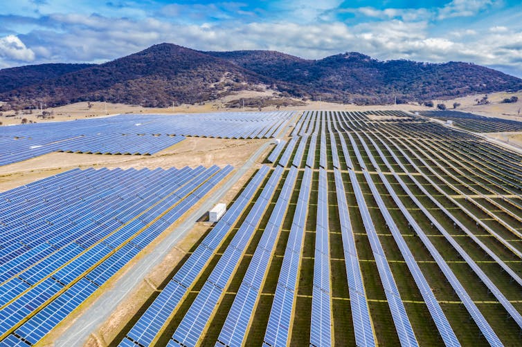 Rows of solar panels with mountain in background