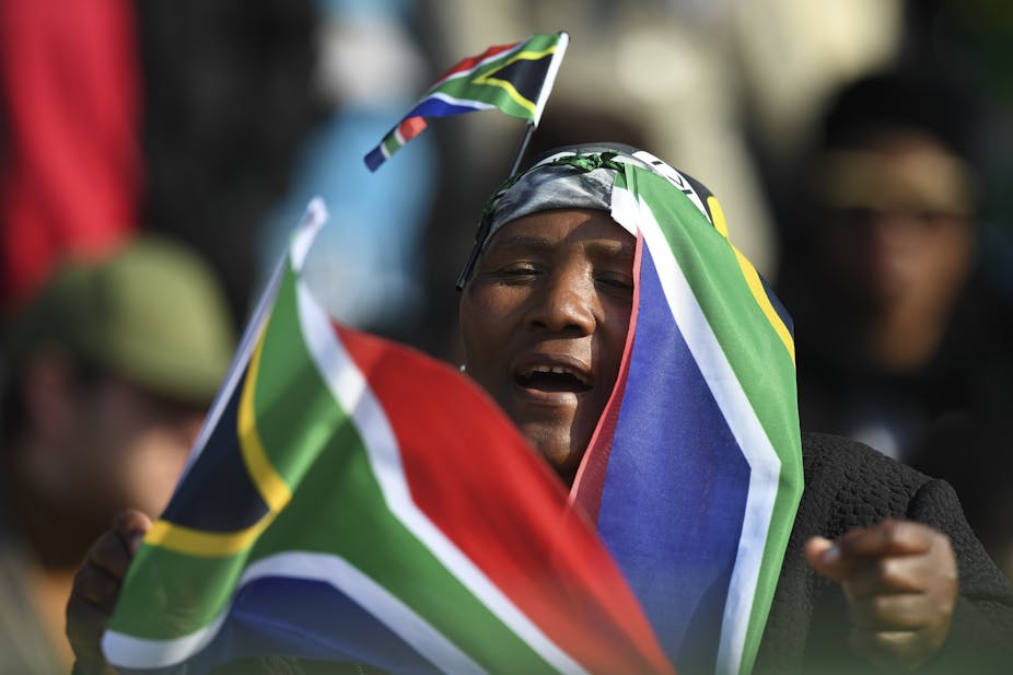 A person holds South African flags
