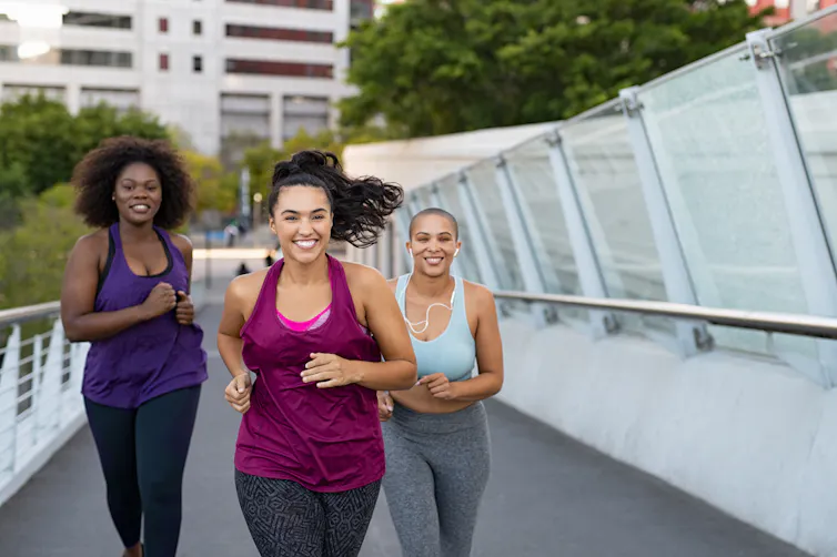 Young women running over a bridge.