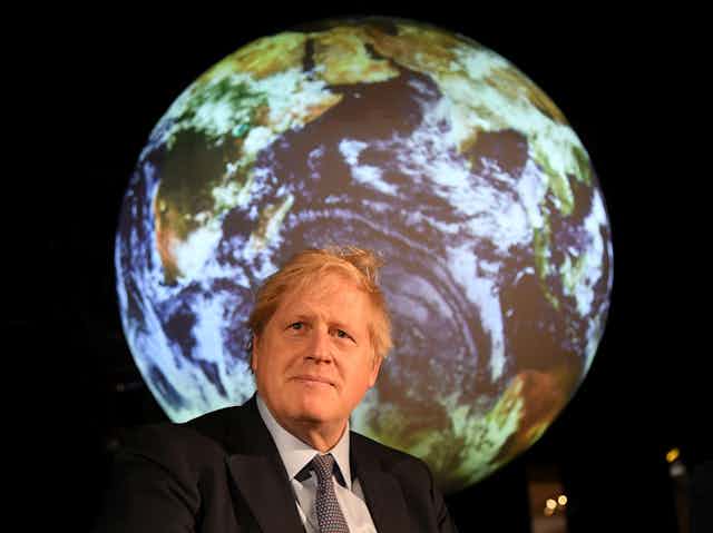 Boris Johnson in front of an image of the globe.