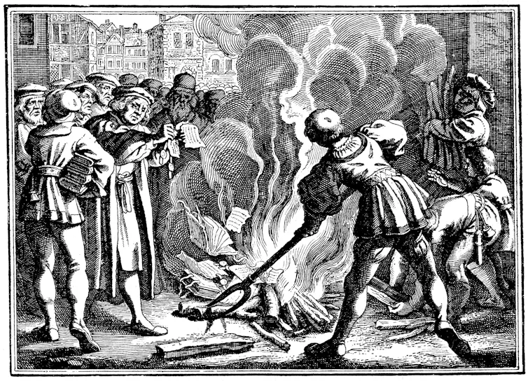 A crowd stands around a flame as a man burns papers in this black and white drawing.