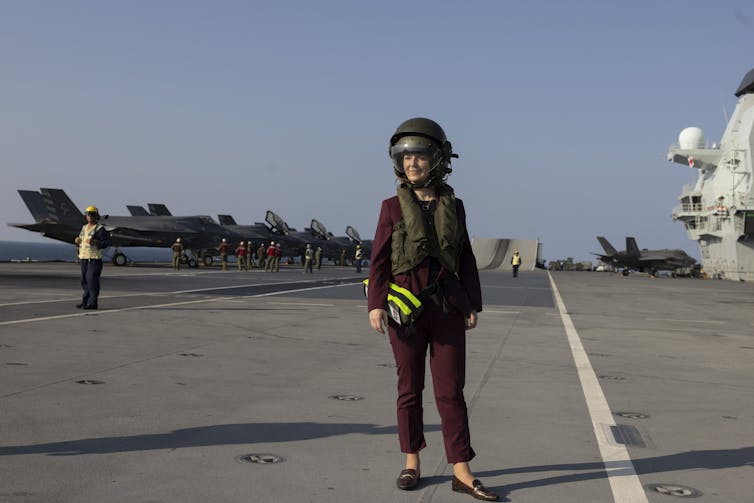 Liz Truss standing on the deck of an aircraft carrier.