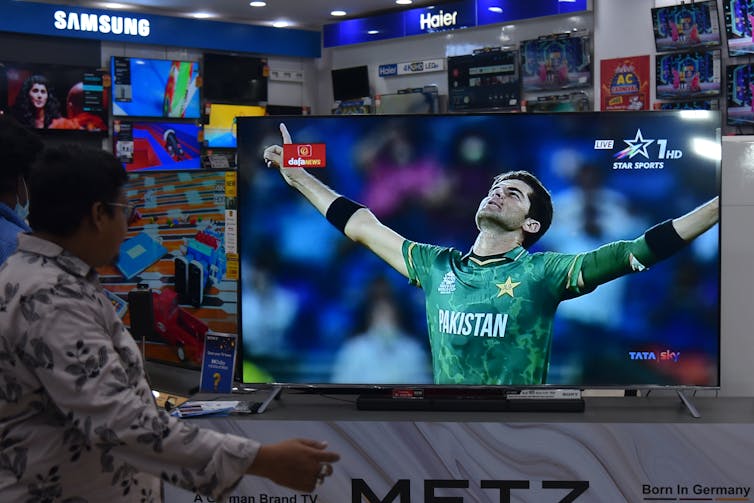 An Indian man watches Pakistan beat India in the T20 Cricket World Cup on a television in an electronics store in Mumbai, October 2021.