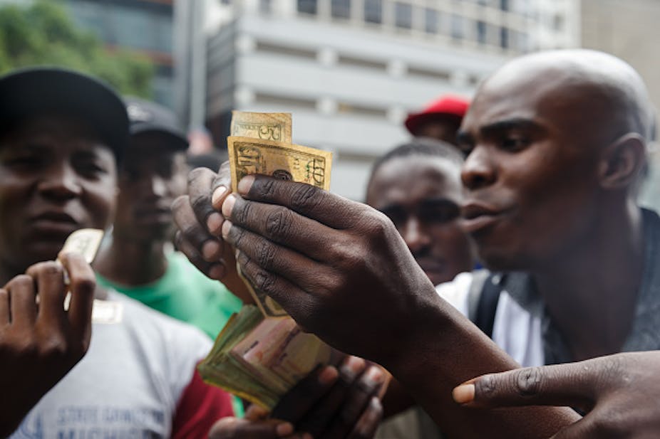 Men holding banknotes haggle over exchange rates.