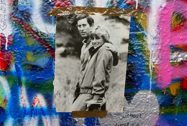 Photo of Prince Charles and princess Diana taped to a graffitied wall