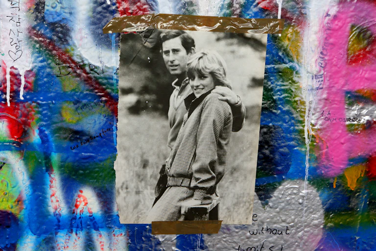Photo of Prince Charles and princess Diana taped to a graffitied wall