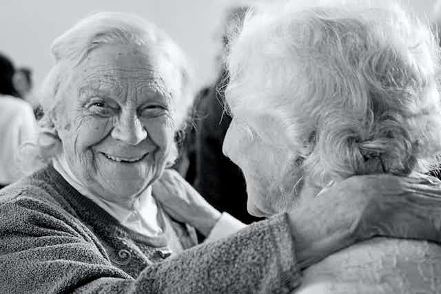 Deux vieilles femmes enlacées et souriantes