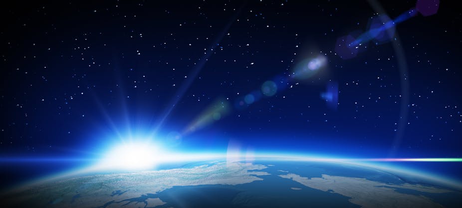 does gravity travel at the speed of light Sun rising over Earth with light flaring into space.