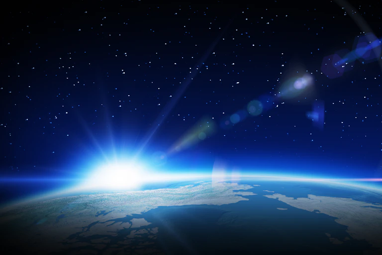 Sun rising over Earth with light flaring into space.