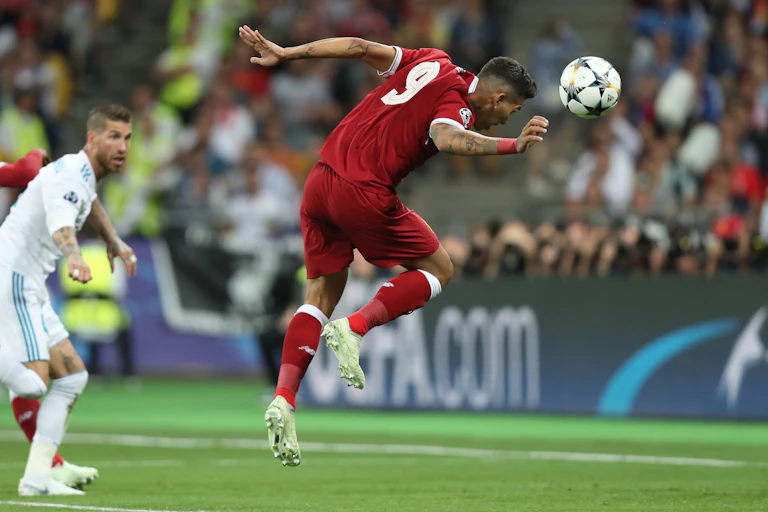 A professional footballer heads the ball.