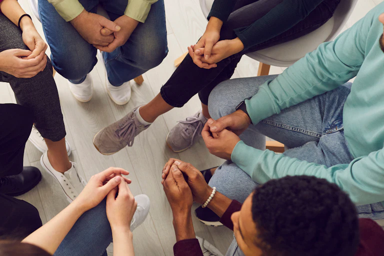 An overhead shot of a group of people engaged in a group therapy session.
