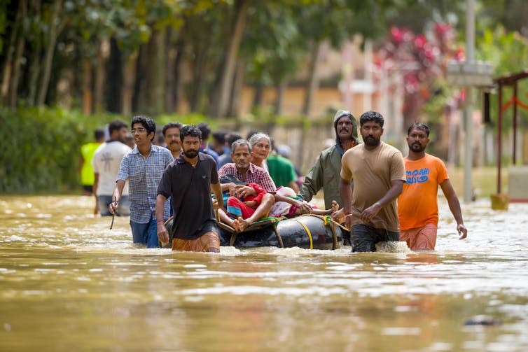 Personas caminan por una calle inundada