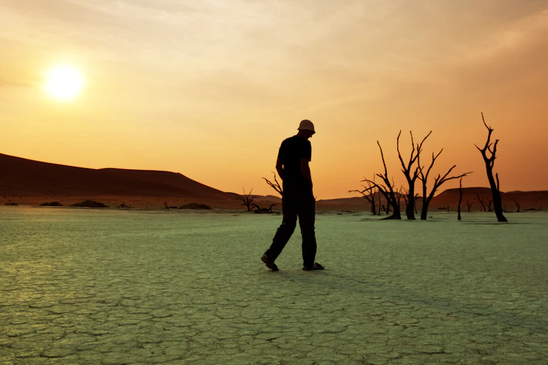 Man walks through dry lake bed