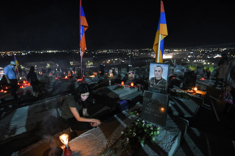 Une femme se recueille sur la tombe d'un soldat tué au combat
