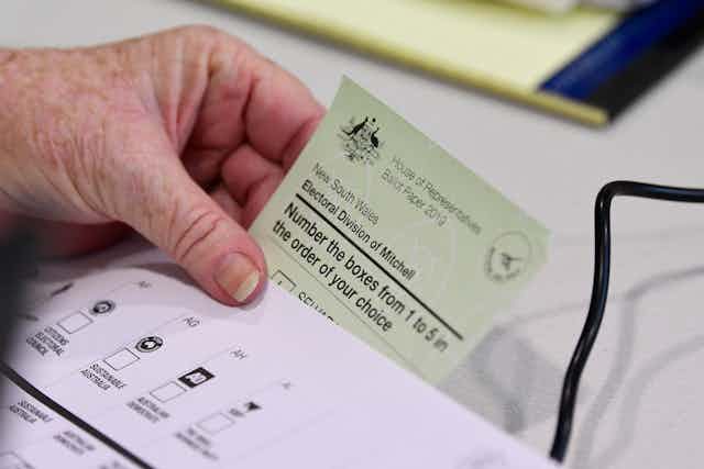 Hand holding an Australian ballot paper