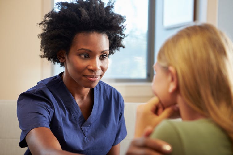 Doctor or nurse putting hand on patient's shoulder