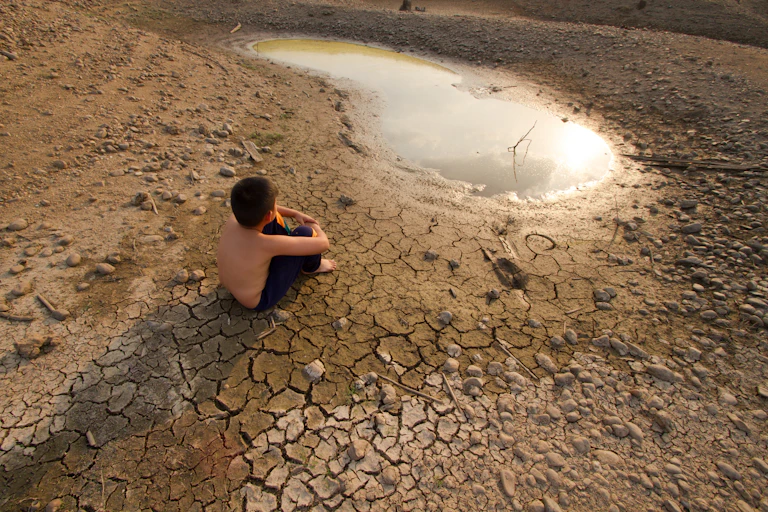 Boy next to drying dam