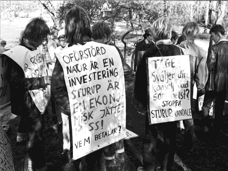 People wearing placards with anti-airport slogans