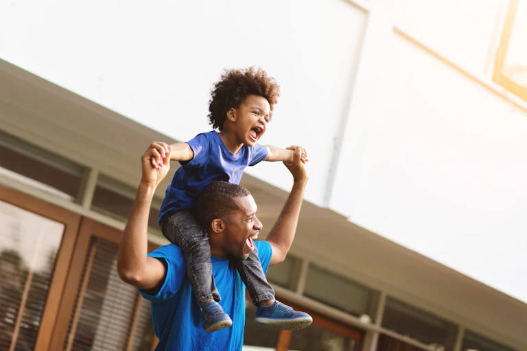 Father carrying his son on his shoulders.