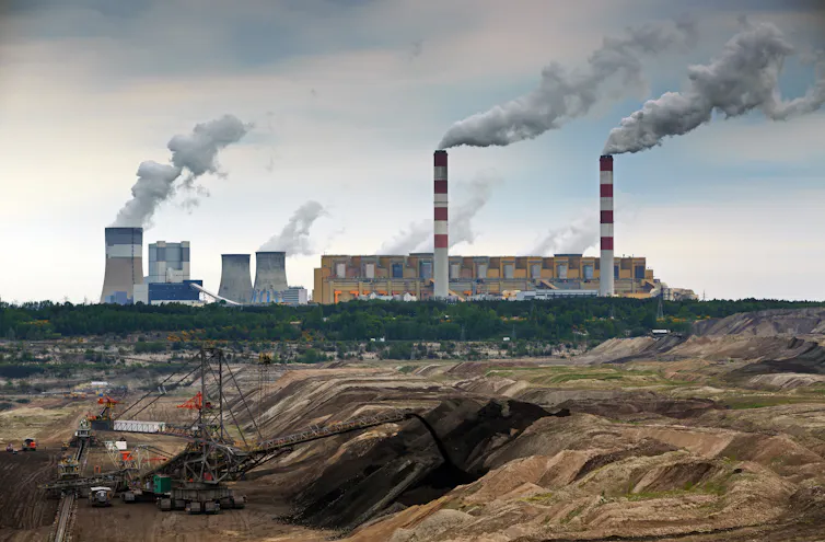 A coal-fired power station belching steam and smoke.