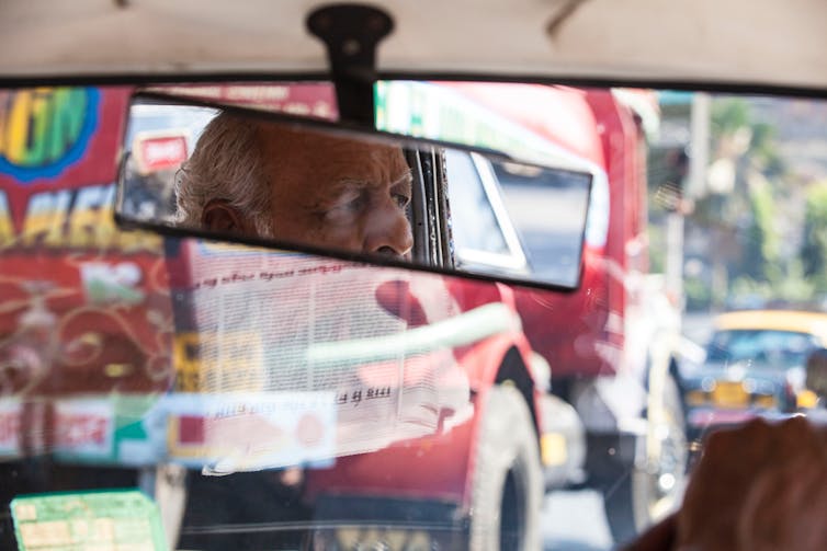 Taxi driver looking in rear mirror in traffic