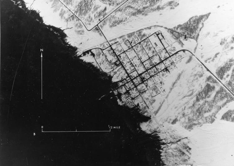 a black and white aerial photograph of a damaged shoreline