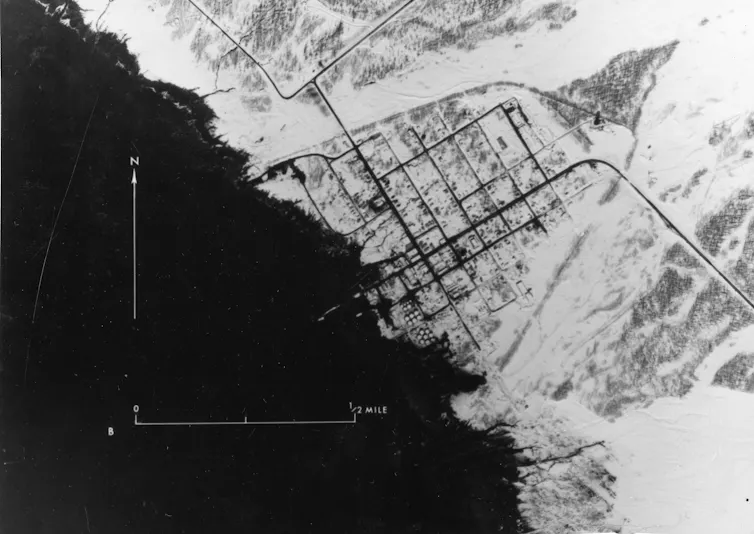 a black and white aerial photograph of a damaged shoreline
