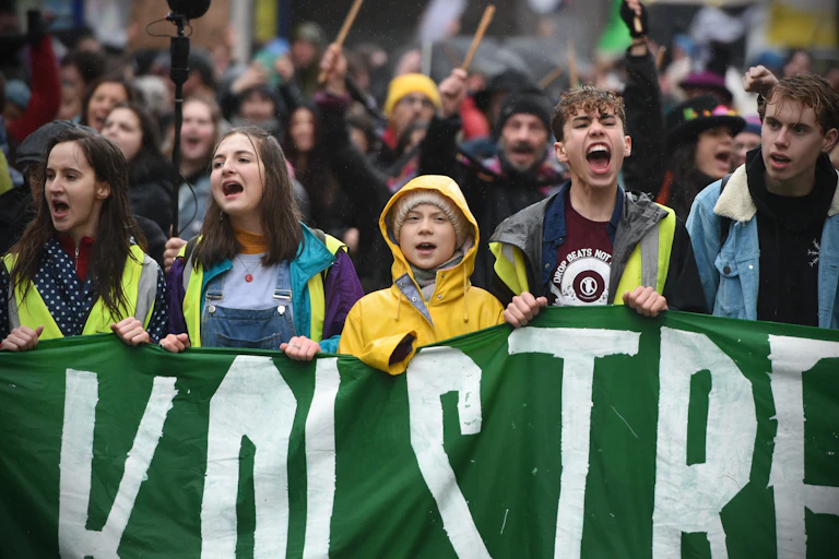 Protesters behind a green banner