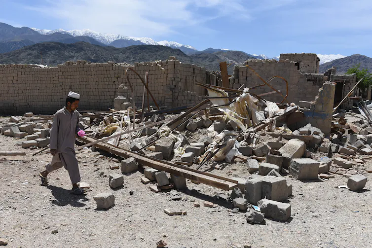 Man treads through debris.