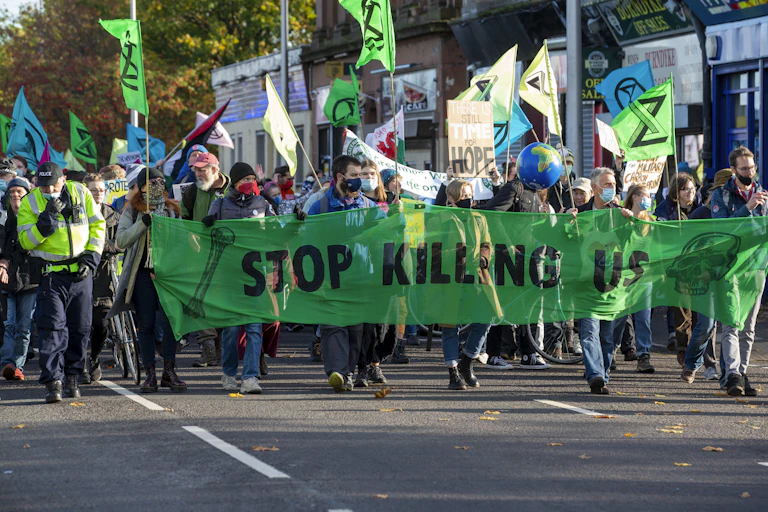 people march in protest with sign reading 'stop killing us'