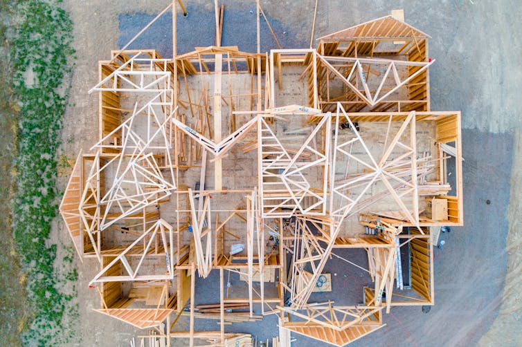 A timber-frame building under construction, seen from above