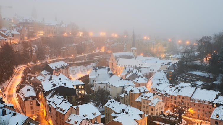 Snow falls on a city neighbourhood