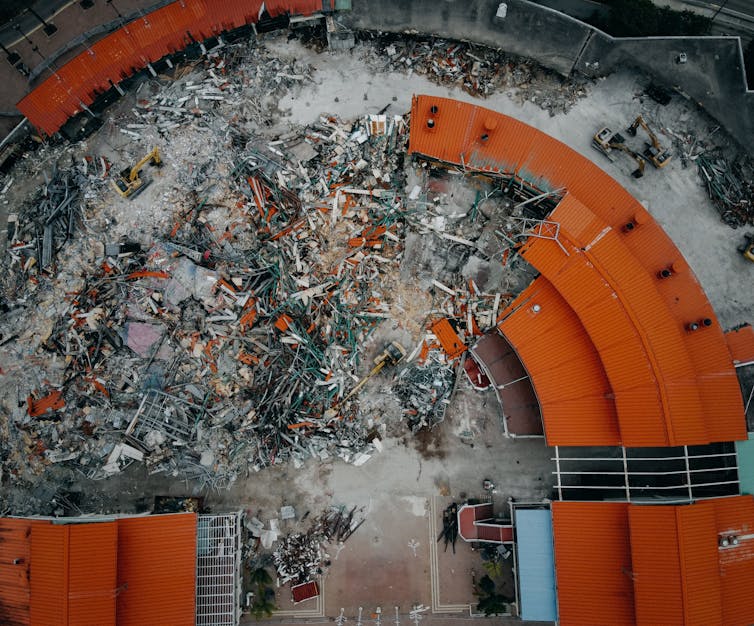 An overhead view of a red-rood building partially demolished