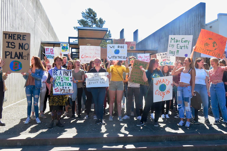 A group of young people hold climate-related signs