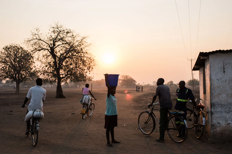 People bike and carry water in a dry village in Malawi during a drought.
