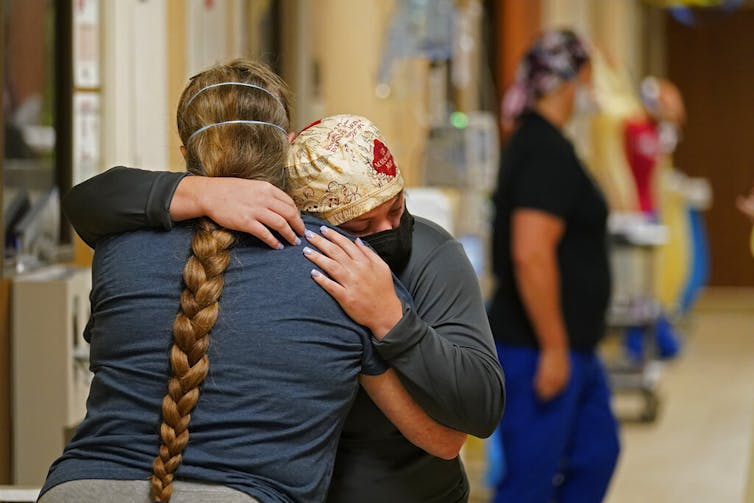 ICU nurse hugging the sister of a deceased patient.