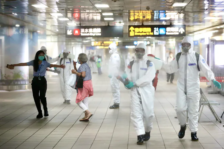 People spraying at an airport to kill coronavirus.