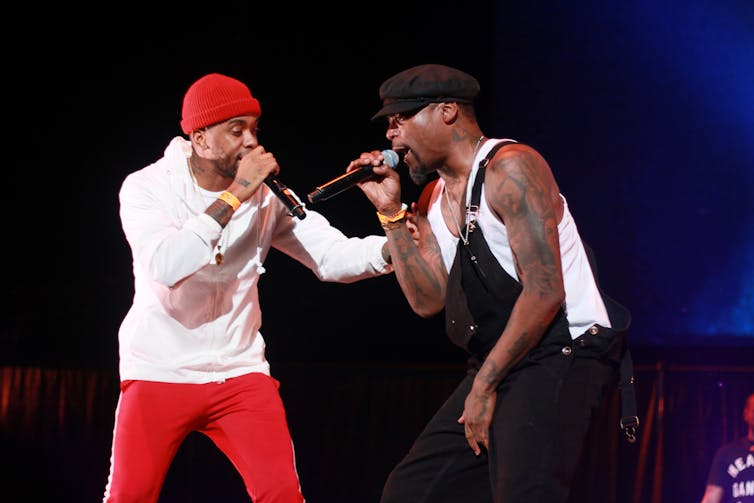 Two rappers perform on stage.