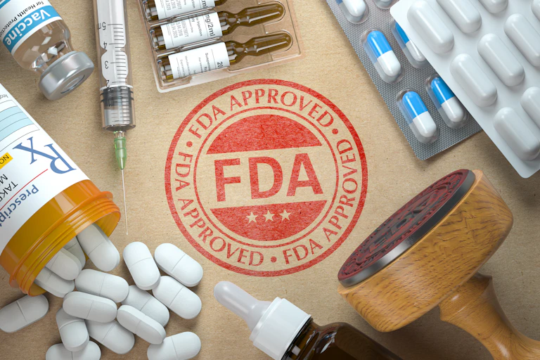 The FDA "stamp of approval" surrounded by prescription pills and other medication
