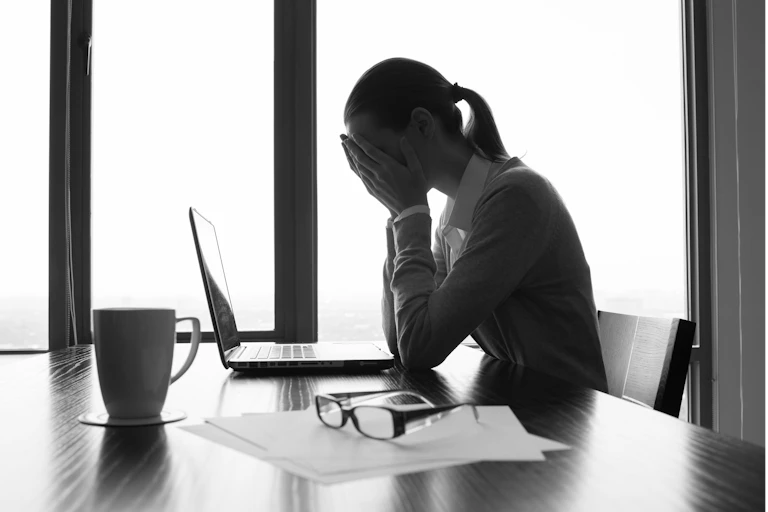 Office worker head in hands looking fatigued