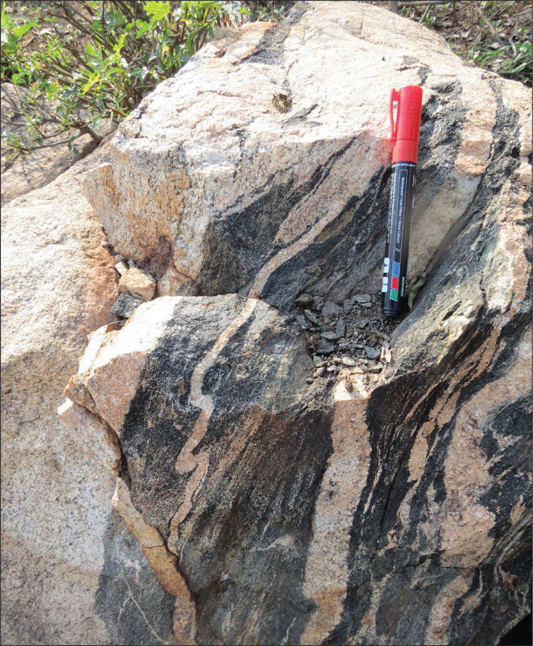 Granite formation with pen for scale.