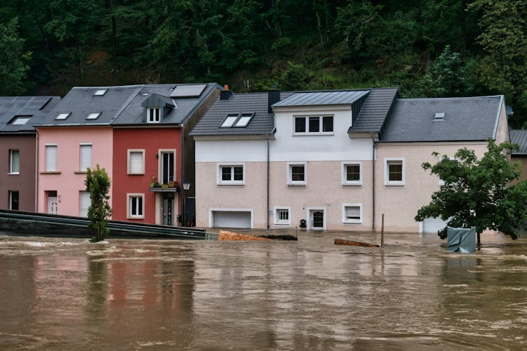 Water rises up the side of a row of houses