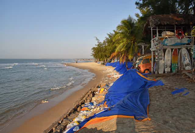 A tropical beach with a makeshift sea wall.