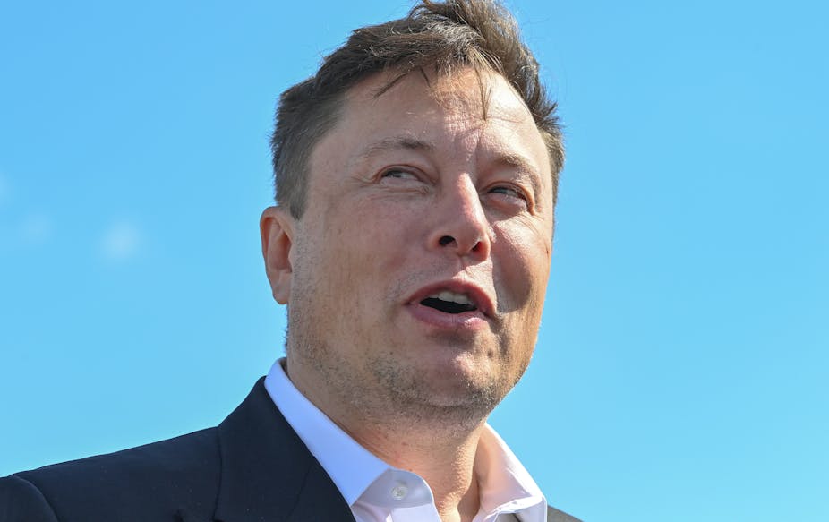 Elon Musk pictured against a bright blue sky