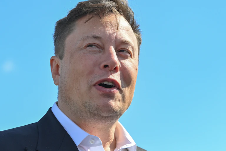 Elon Musk pictured against a bright blue sky