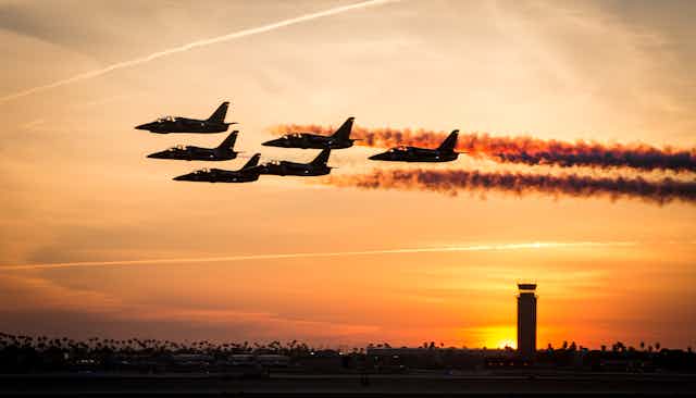Small jet planes in formation at sunset