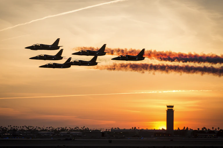 Small jet planes in formation at sunset